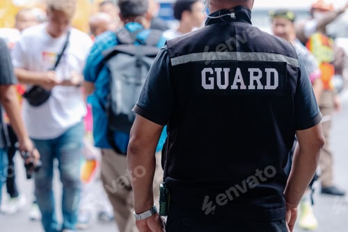 Preview: closeup security guard man in public area standing secure people or place outdoor.
