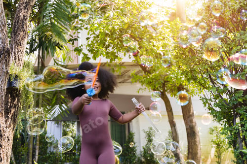 Preview: African American girl blowing bubbles. preschool kid, enjoy happy time in the park