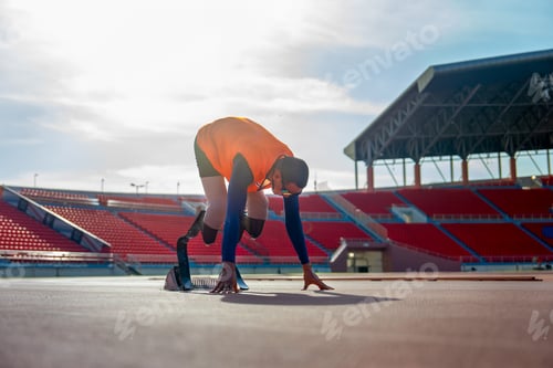 Preview: Sport man athlete prosthesis legs with orange cloth stay in the position of start running