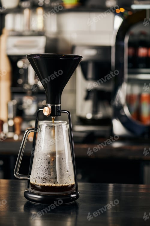 Preview: siphon coffee maker with fresh espresso in glass coffee pot on black wooden table in modern cafe
