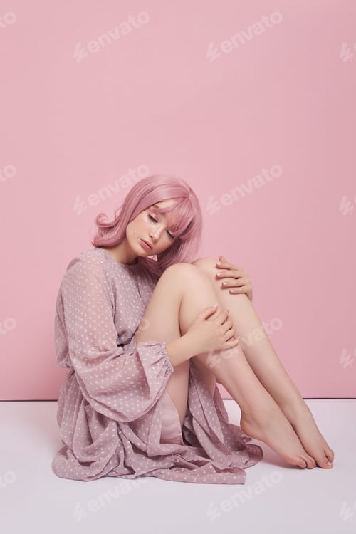 Preview: Woman with dyed pink hair in a long dress is sitting on the floor. Portrait of a girl hair coloring