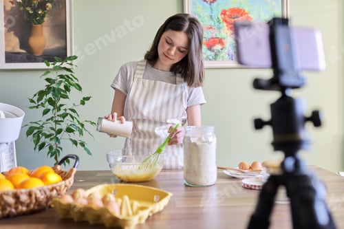Preview: Girl teenager food blogger cooking orange pancakes at home in kitchen