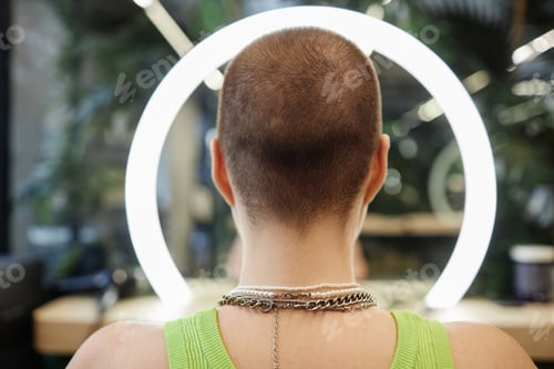Preview: Back View of Young Woman with Buzzcut in Beauty Salon