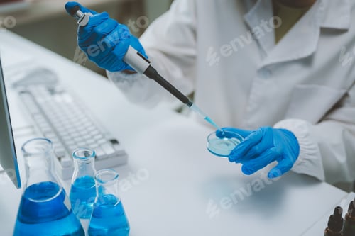 Preview: Scientist pipetting blue liquid into petri dish in lab