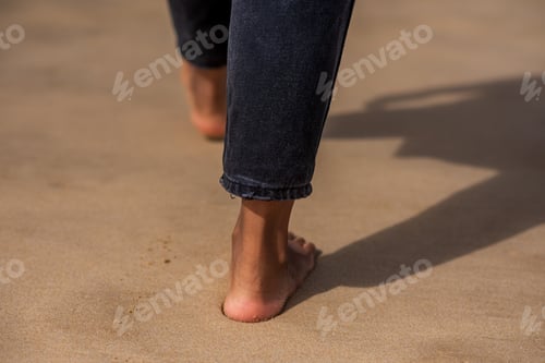 Preview: Woman walking bare feet along coast