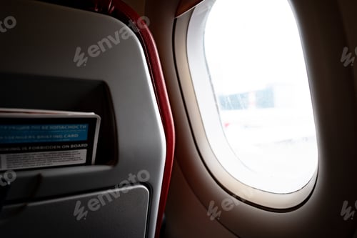 Preview: Seats and window inside a dark aircraft