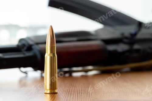 Preview: One bullet against blurred Kalashnikov assault rifle. Cartridge 7.62 caliber for ak 47