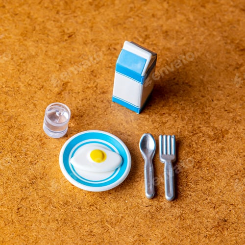 Preview: Miniature eggs with milk pack, fork and spoon on wooden table.