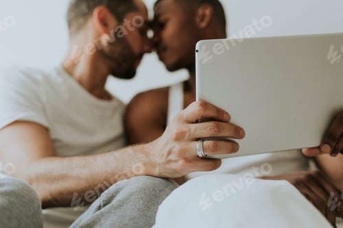 Preview: Gay couple using a tablet in bed