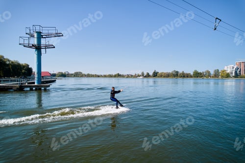 Preview: Young surfer having fun wakeboarding in the cable park.
