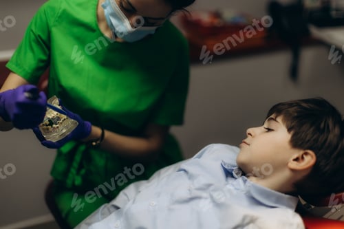 Preview: Dentist Demonstrating Dental Model to Young Patient in Clinic Setting