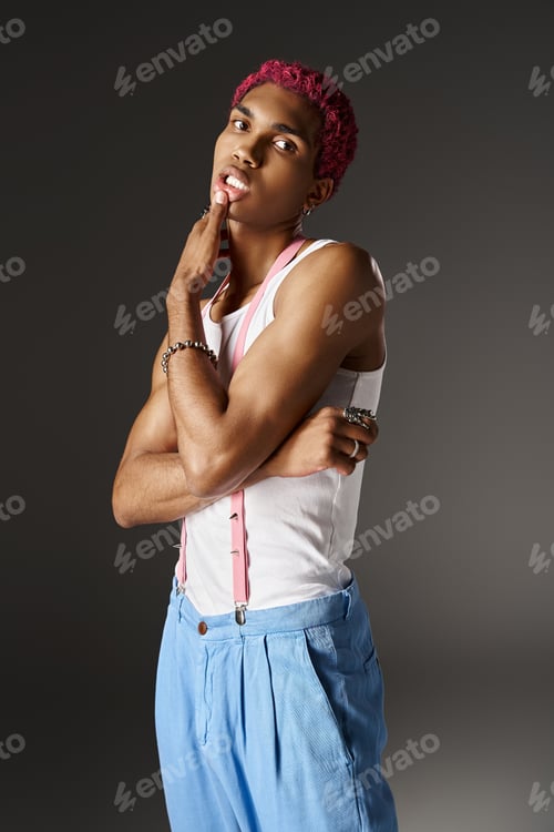 Preview: pink haired african american man with finger on his lips and crossed arms on gray backdrop, fashion