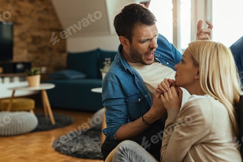 Preview: Angry man screaming at his girlfriend while having a conflict at home.