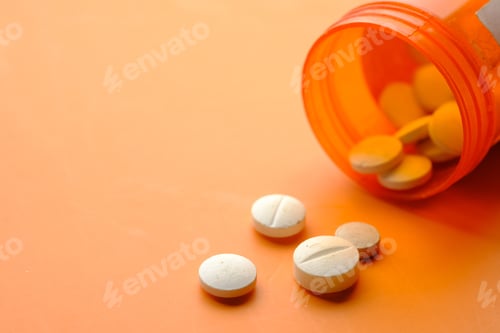 Preview: white color medical pills spilling on orange background