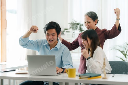 Preview: Excited asian business team celebrating victory together in office.