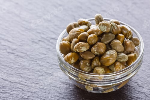 Preview: pickled capers on a dark stone background