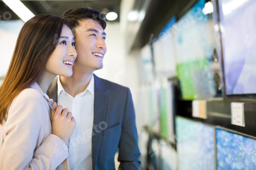 Preview: Young couple buying television in electronics store