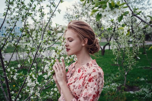 Preview: Young beautiful woman in the cherry-blossoming garden