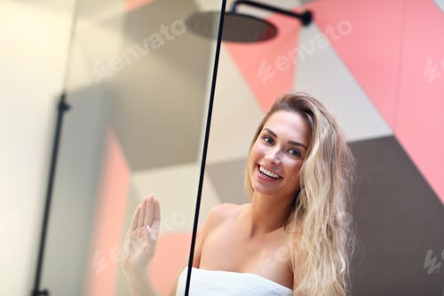 Visualização: Linda mulher loira caucasiana posando no banheiro com o cabelo molhado