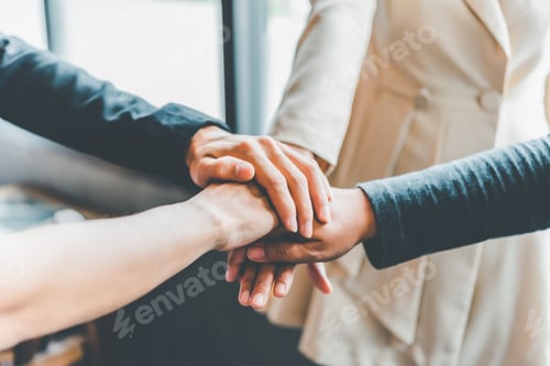 Preview: Hands of business people come together in a stack of hands to symbolize collaboration