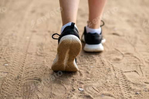 Preview: Close-up of woman’s legs in sneakers running on sandy beach, active lifestyle and fitness outdoors