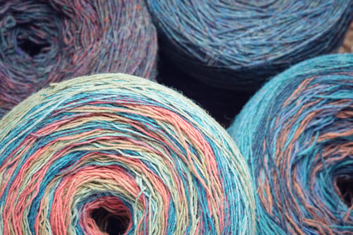 Preview: Round skeins of organic multi-coloured lambswool yarn.