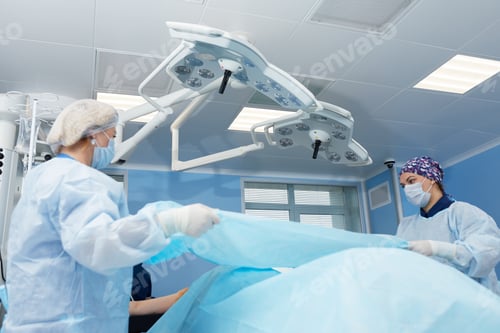 Preview: Concentrated Surgical team operating a patient in an operation theater