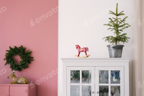 Preview: Christmas Tree in Metal Bucket, Vintage Wooden Red Toy Horse on White Dresser in the Interior