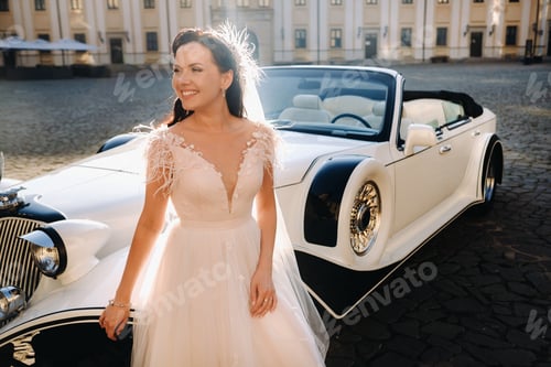 Preview: An elegant bride In the courtyard of the castle near a retro car
