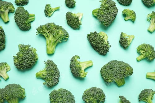 Preview: Fresh tasty broccoli on turquoise background, flat lay