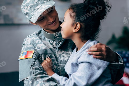 Preview: african american daughter hugging mother in military uniform at home