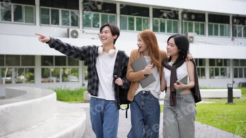 Preview: Three asian students stroll through the university campus, engaged in conversation