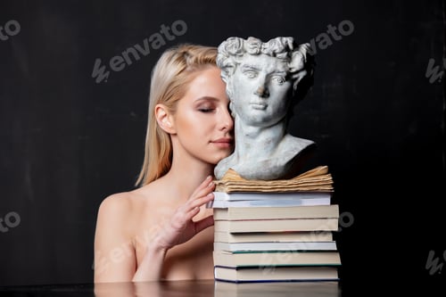 Preview: blonde next to an antique bust of a man on books