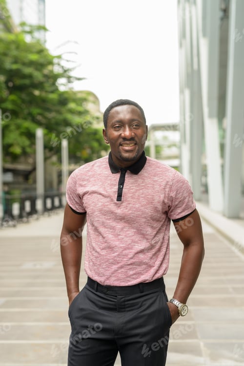 Preview: Portrait of handsome African businessman in city smiling and thinking