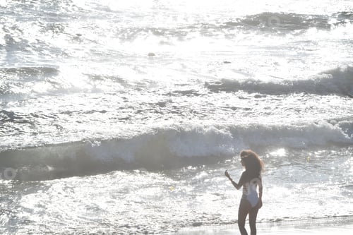 Preview: Beautiful young woman enjoying golden hour at Santa Monica Beach