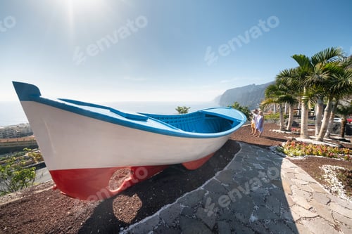 Preview: a couple of lovers at a huge boat, near the beach at the cliffs of Acantilados de Los Gigantes