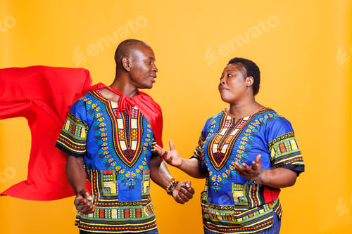 Preview: Woman looking at man dressed in cape