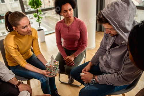 Preview: Diverse group of people sitting in circle in group therapy session.