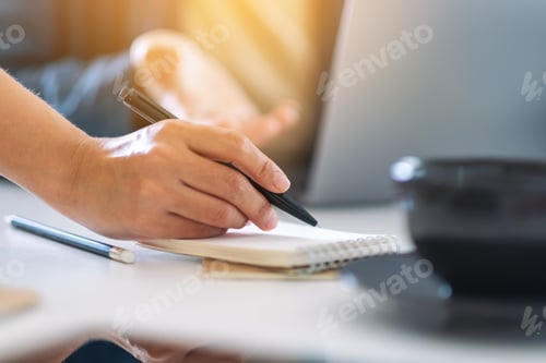Preview: Group of businessman discussing and writing on notebook with laptop computer on the table in office