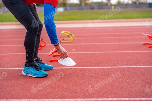 Preview: Mature man preparing an athletic track with training elements