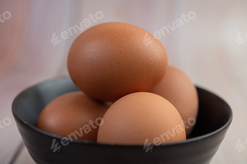 Preview: Eggs placed in a cup on a wooden floor.