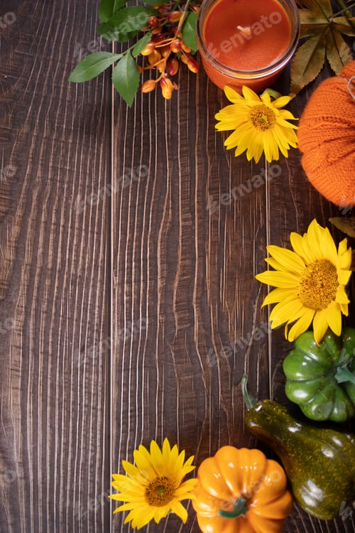 Preview: Autumn wooden background frame with pumpkins, sunflowers and candle. Fall harvest season concept