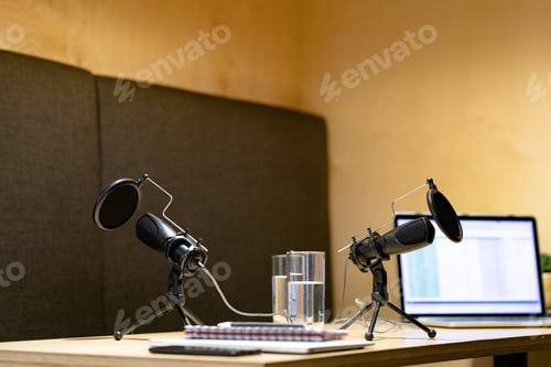 Preview: Office desk with microphones, documents, laptop computer, glasses of water and smartphone