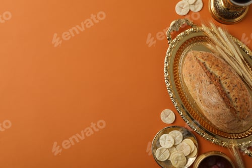 Preview: Bread on golden tray and spikelets on orange background, space for text