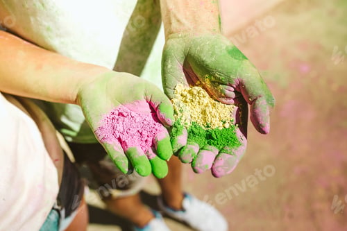 Preview: Beautiful young couple playing in the park on holi colours festi