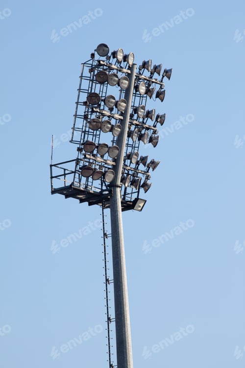 Preview: Vertical shot of a huge stadium light under a clear blue sky