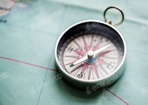 Preview: Closeup of metallic compass on the map journey planning