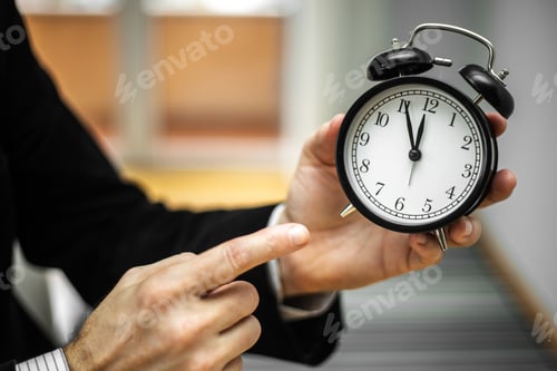 Preview: Businessman holding an alarm clock