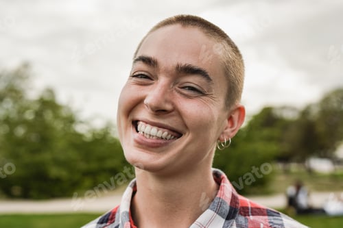 Preview: Happy bald girl smiling on camera at city park