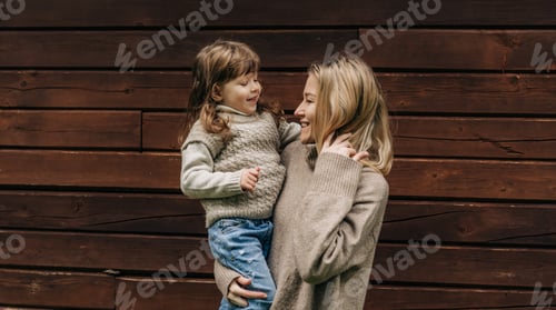 Preview: Happy smiling mother holds a little cheerful daughter in her arms.